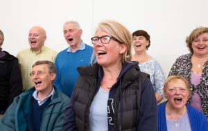 Lindsay is blonde with glasses. She is singing in the Magenta Choir
