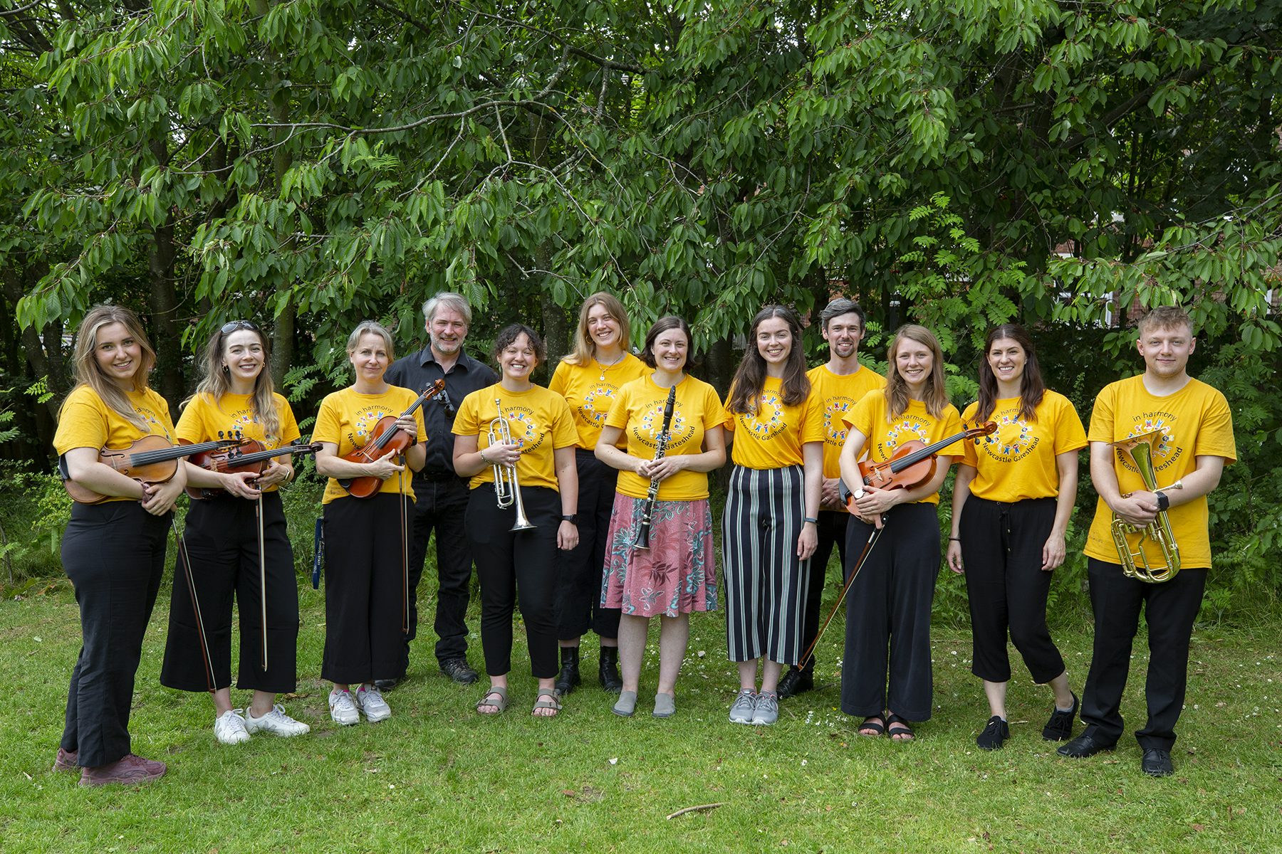 In Harmony Tutors in yellow t shirts with instruments