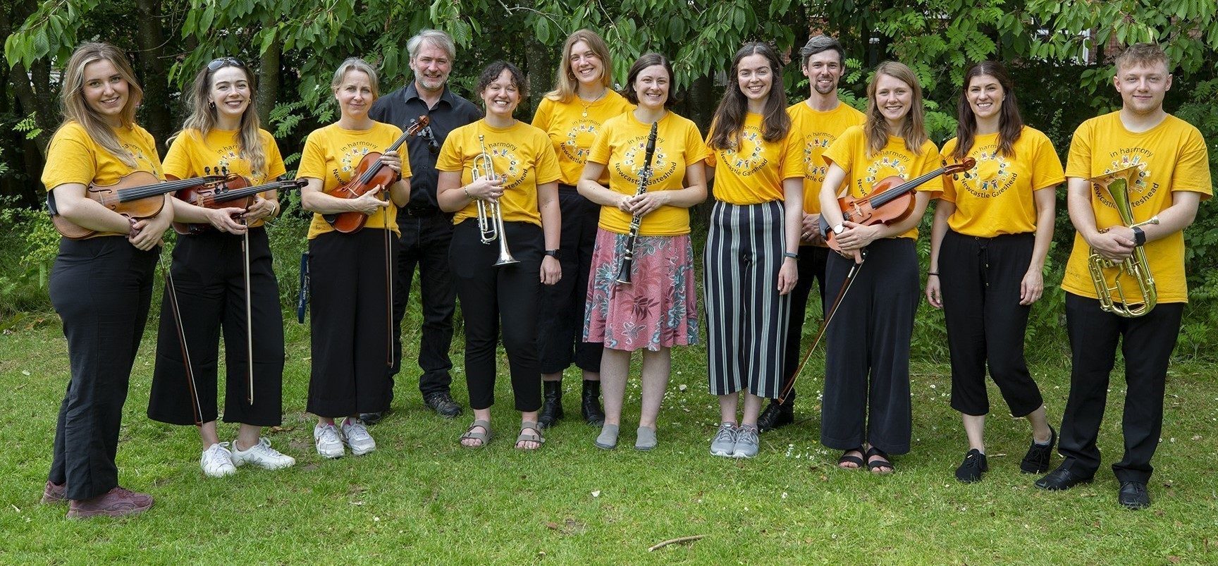 In Harmony tutors in yellow t shirts on a field