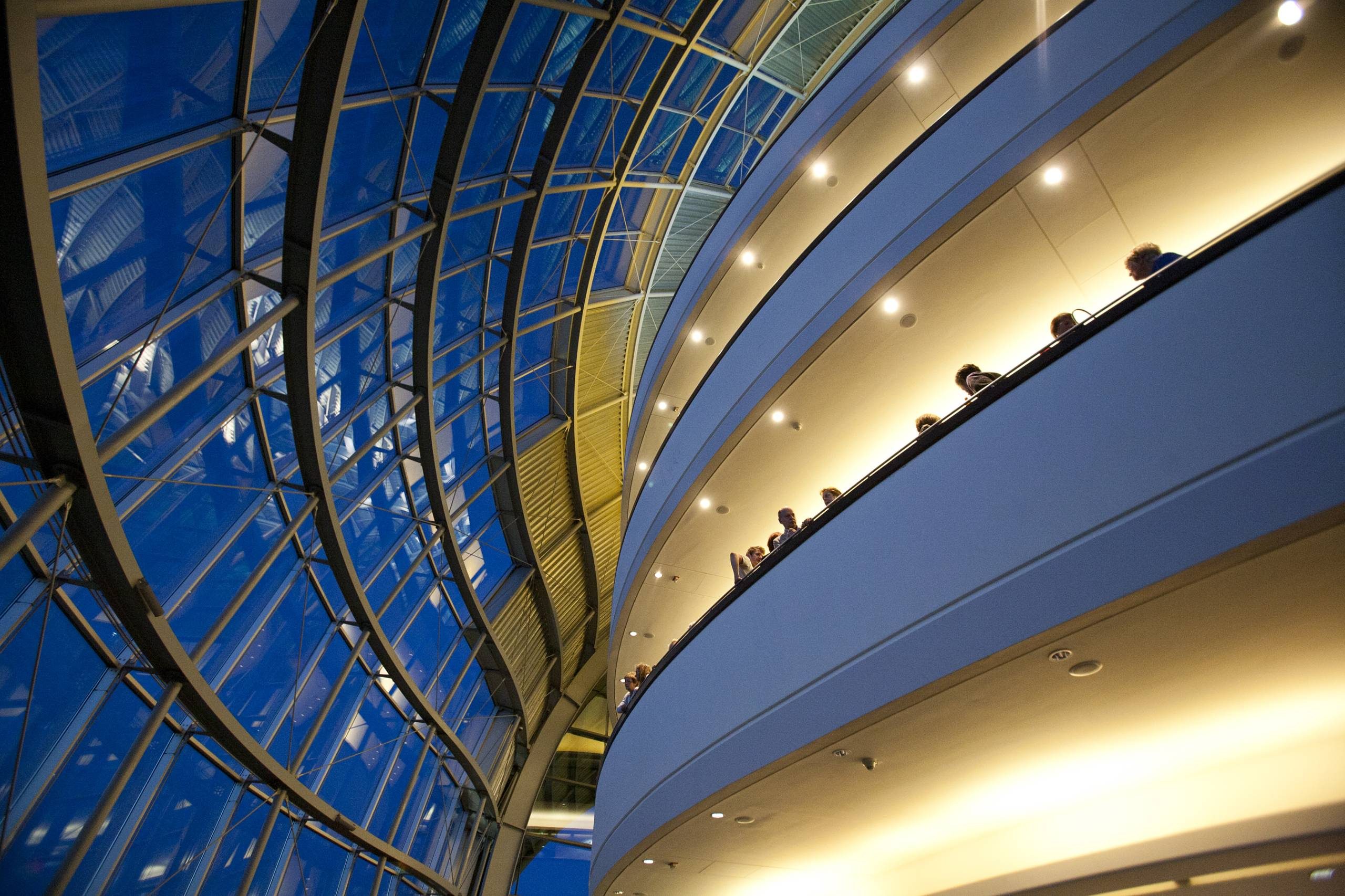 a glass building with balconies radiating warm light
