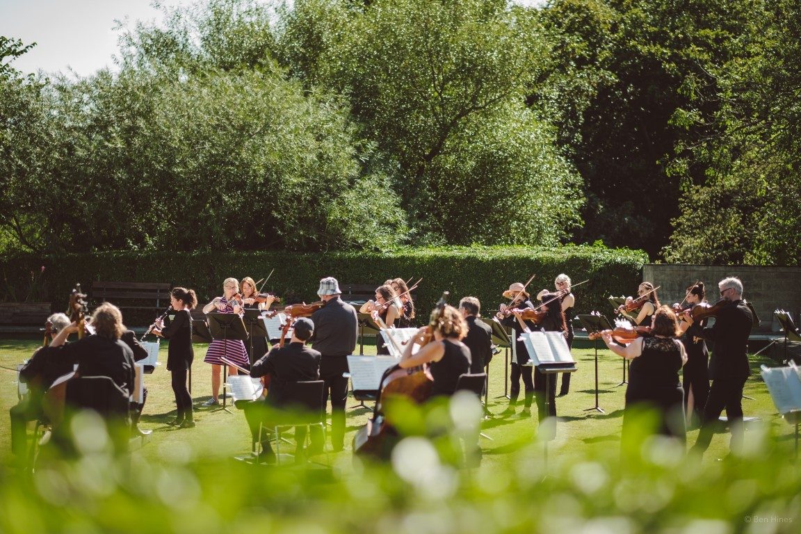 orchestra performing on a green field