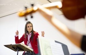 conductor in a red jacket and long hair
