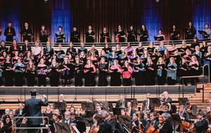 a choir in bright shirts with books in their hands