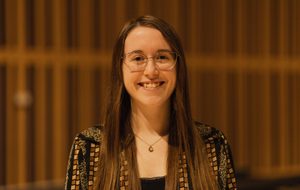 a headshot of a girl with glasses and long brown hair