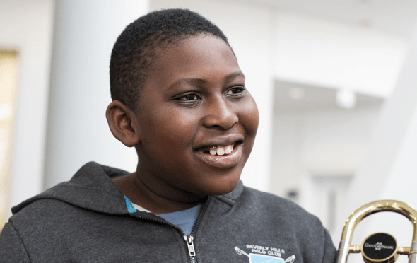 Young musician with trombone and grey top