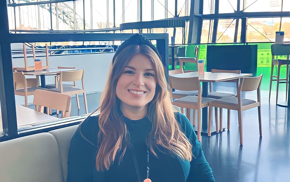 person with long red hair and a green dress