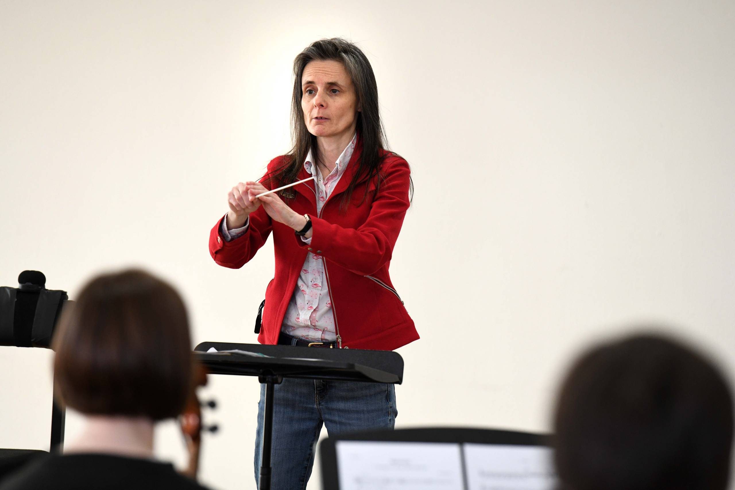 a conductor in a red jacket with long hair
