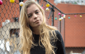 Blonde woman with long hair and a black jumper
