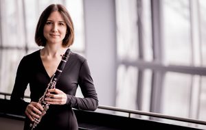 Person in a black dress holding a clarinet