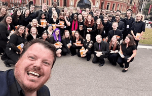 A choir wih their leader standing in front of Royal Albert Hall
