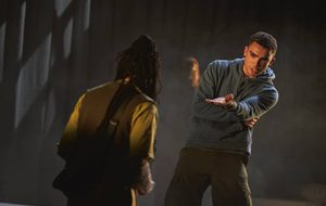 a man in a blue hoodie acting on stage.