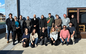 a group of people standing in front of a blue wall