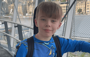 Trystan with blonde hair and a blue top