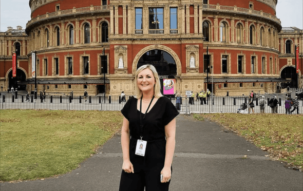 Lou Duff in a black outfit in front of the Royal Albert Hall.
