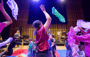 A person throwing scarves at the Big Family Gig for refugees and asylum seekers