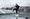 Dancer performing outdoors on a wet industrial rooftop.