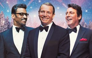 Performers in black bow ties and suits, on a blue and pink sparkly background.